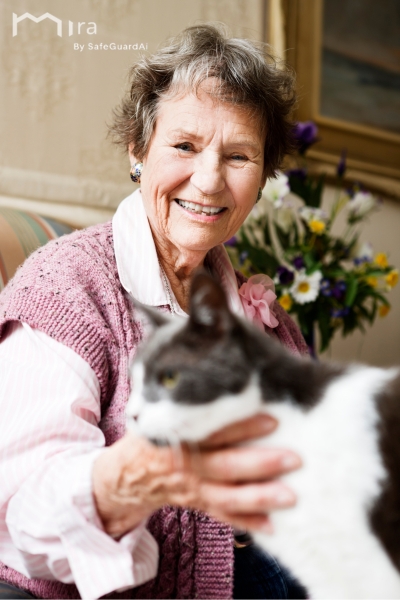 Elderly woman safely at home with her cat, protected by Mira